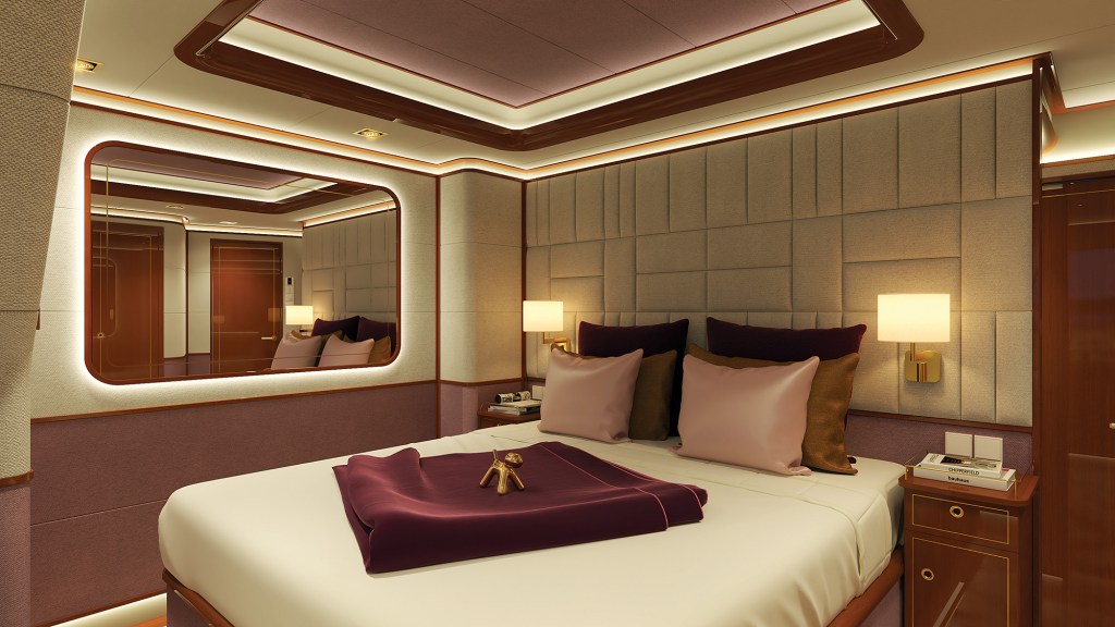 An interior rendering of a luxurious and warmly lit owner's stateroom cabin on a yacht. A large double bed takes center stage, neatly made with crisp white sheets, a folded maroon blanket, and a small gold dog sculpture resting on top. The headboard wall features an elegant grid of textured beige upholstered panels, flanked by two glowing brass bedside lamps and matching wooden nightstands. On the left wall, a large, rounded rectangular mirror with integrated warm LED backlighting reflects the room's polished wood trim and a doorway in the distance.