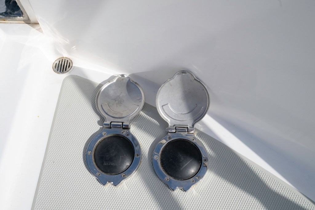 Two deck-mounted Maxwell foot switches with open stainless-steel protective covers revealing the black rubber activation pads.