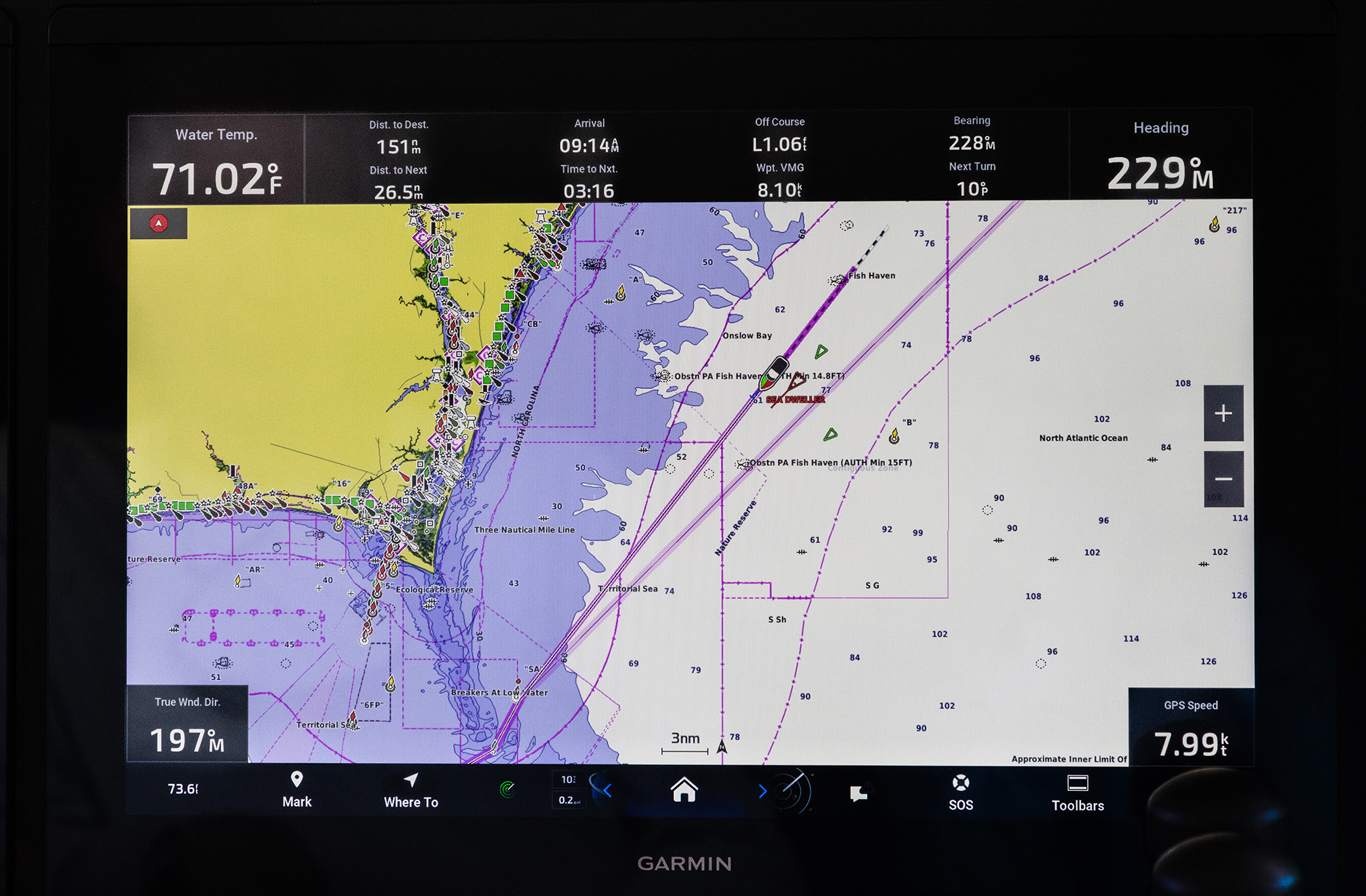 A Garmin marine chartplotter display screen showing a digital nautical map with AIS vessel tracking, route waypoints, and navigation data overlay.