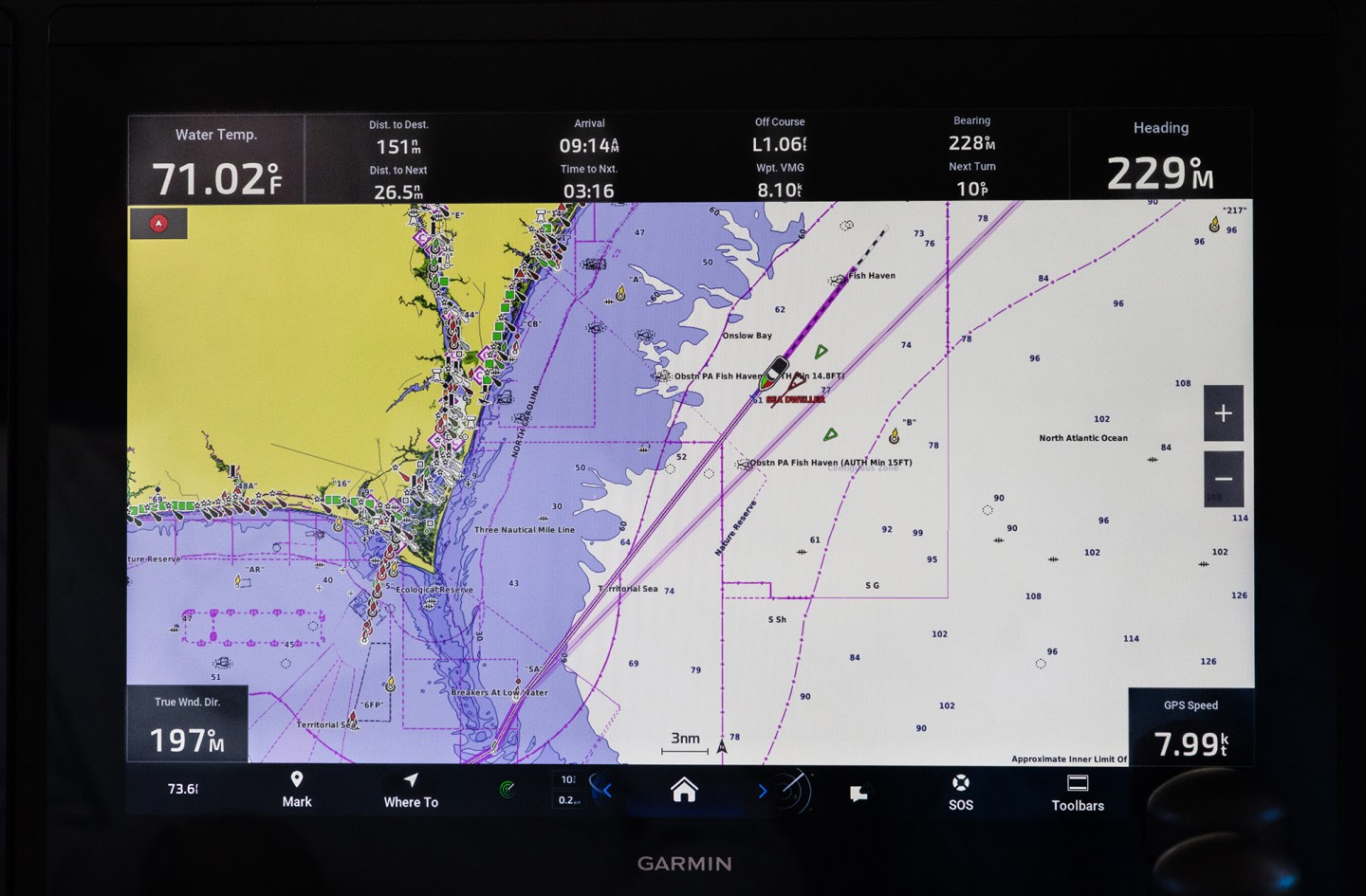 A Garmin marine chartplotter display screen showing a digital nautical map with AIS vessel tracking, route waypoints, and navigation data overlay.