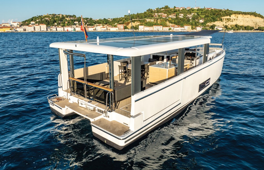 Stern view of the Jeanneau Sea Loft 480 monomoran on the water, showing its twin-hull aft design, swim platform, and open main deck layout.