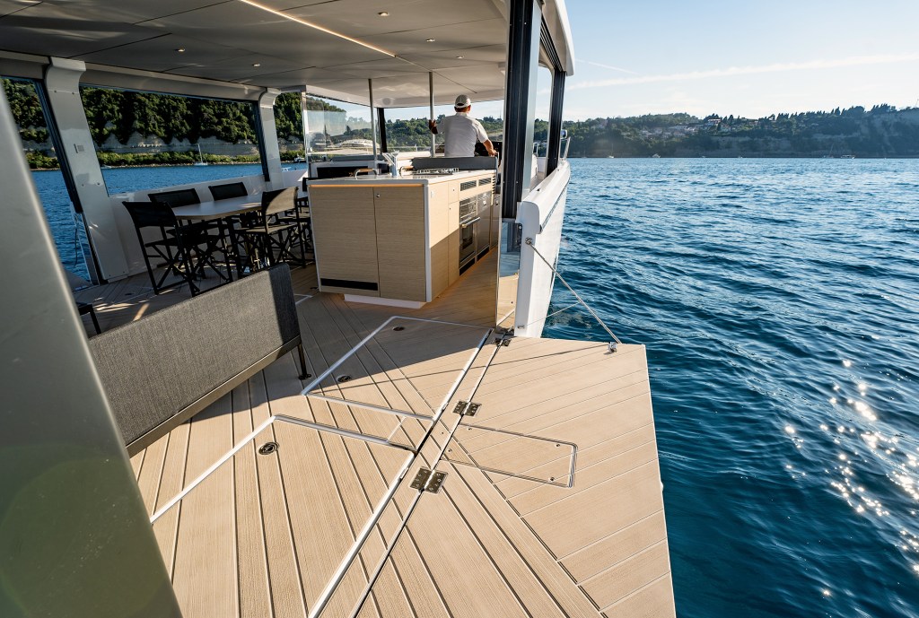 A extended side terrace created by a lowered bulwark on the Jeanneau Sea Loft 480, expanding the main deck living space right over the water.
