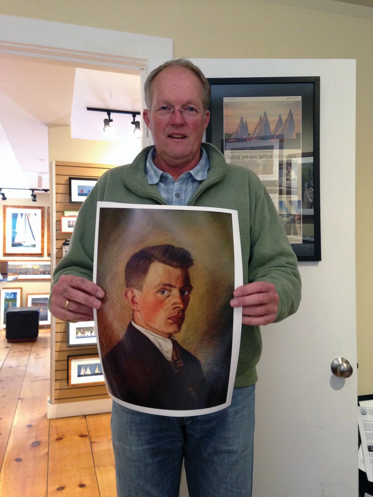 Photographer Onne van der Wal standing indoors holding a printed portrait painting of his grandfather.