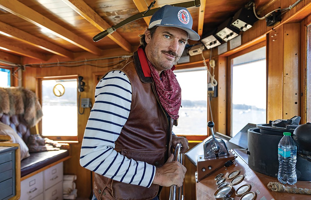 Captain S. Davis Alford at the wheel in the pilothouse of the historic Robert Gray ship.
