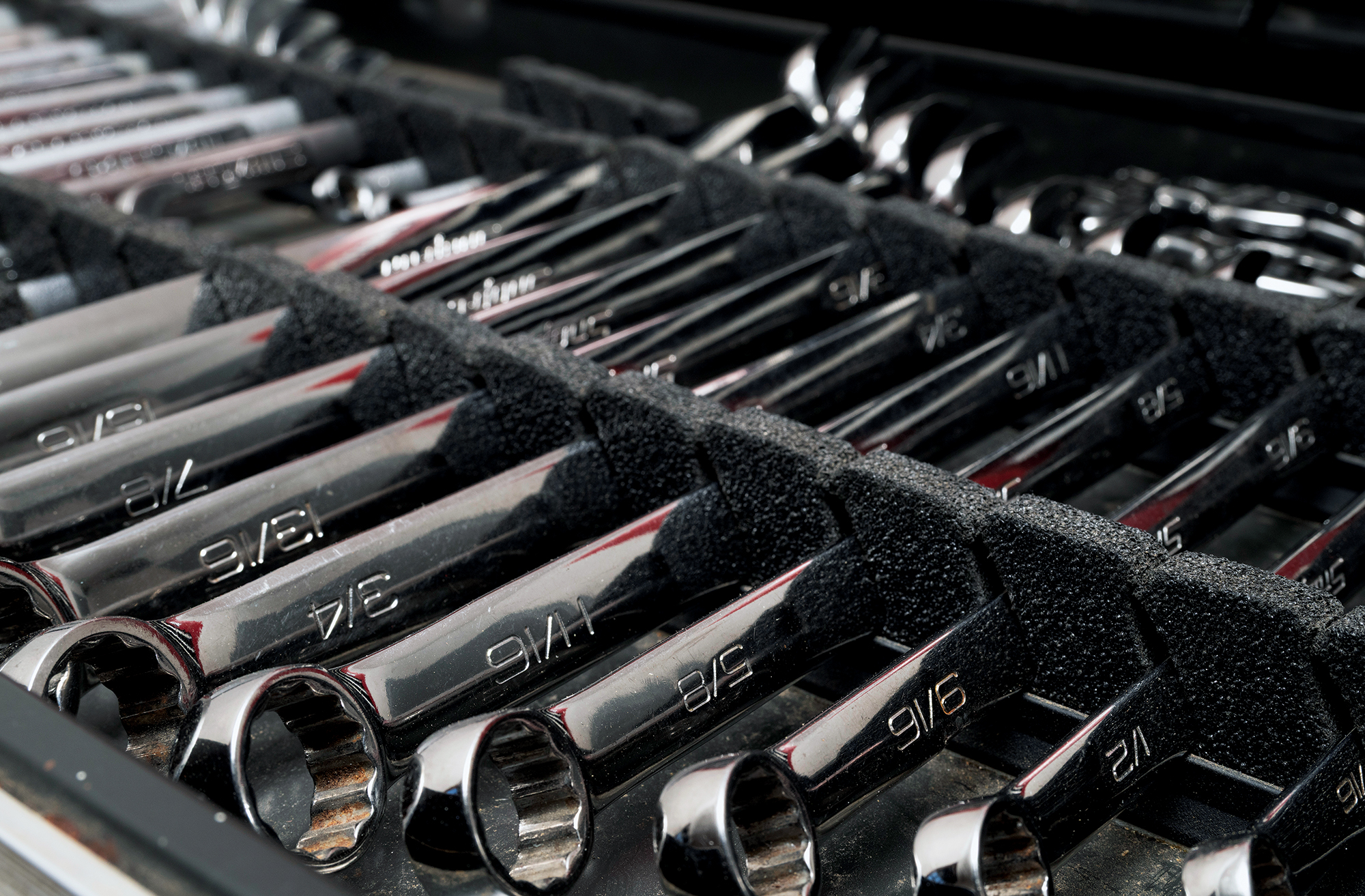 Organized set of chrome combination wrenches in foam storage tray inside a boat toolbox.