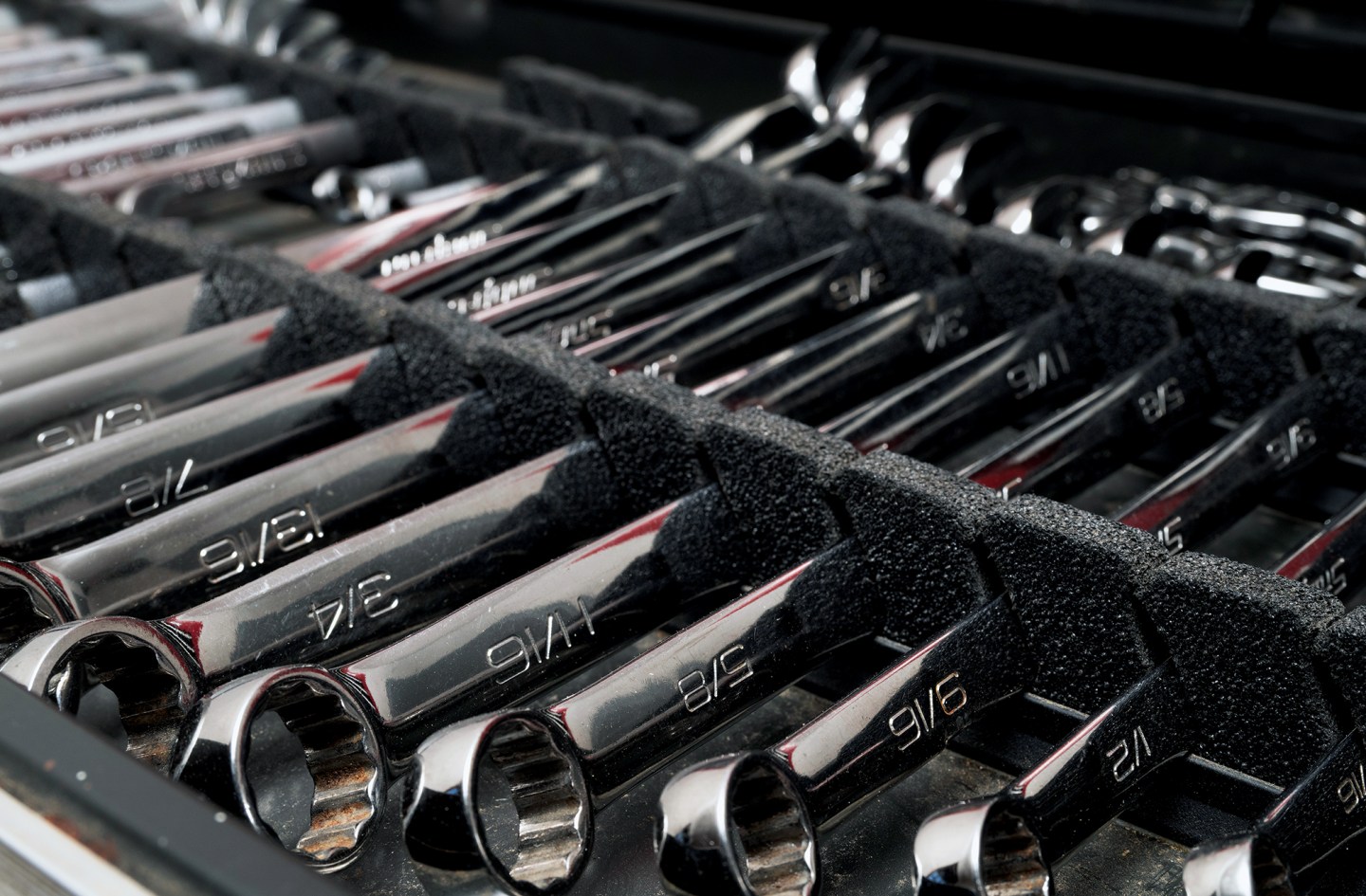 Organized set of chrome combination wrenches in foam storage tray inside a boat toolbox.