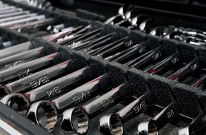 Organized set of chrome combination wrenches in foam storage tray inside a boat toolbox.