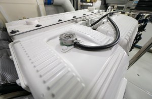 feat_system_crashers Close-up of a white marine diesel engine heat exchanger with a metal cap during routine preventive maintenance.