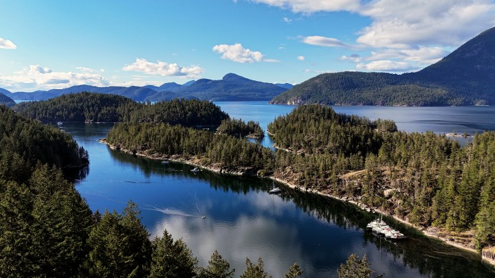 Aerial view of Melanie Cove at Prideaux Haven showing boats anchored among lush, forested islands in Desolation Sound.