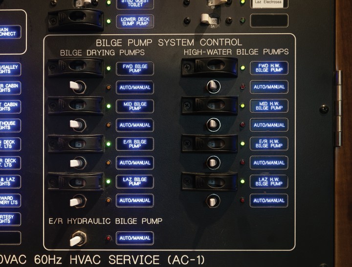 A marine bilge pump system control panel featuring illuminated toggle switches and indicator lights divided into drying pumps and high-water pumps.